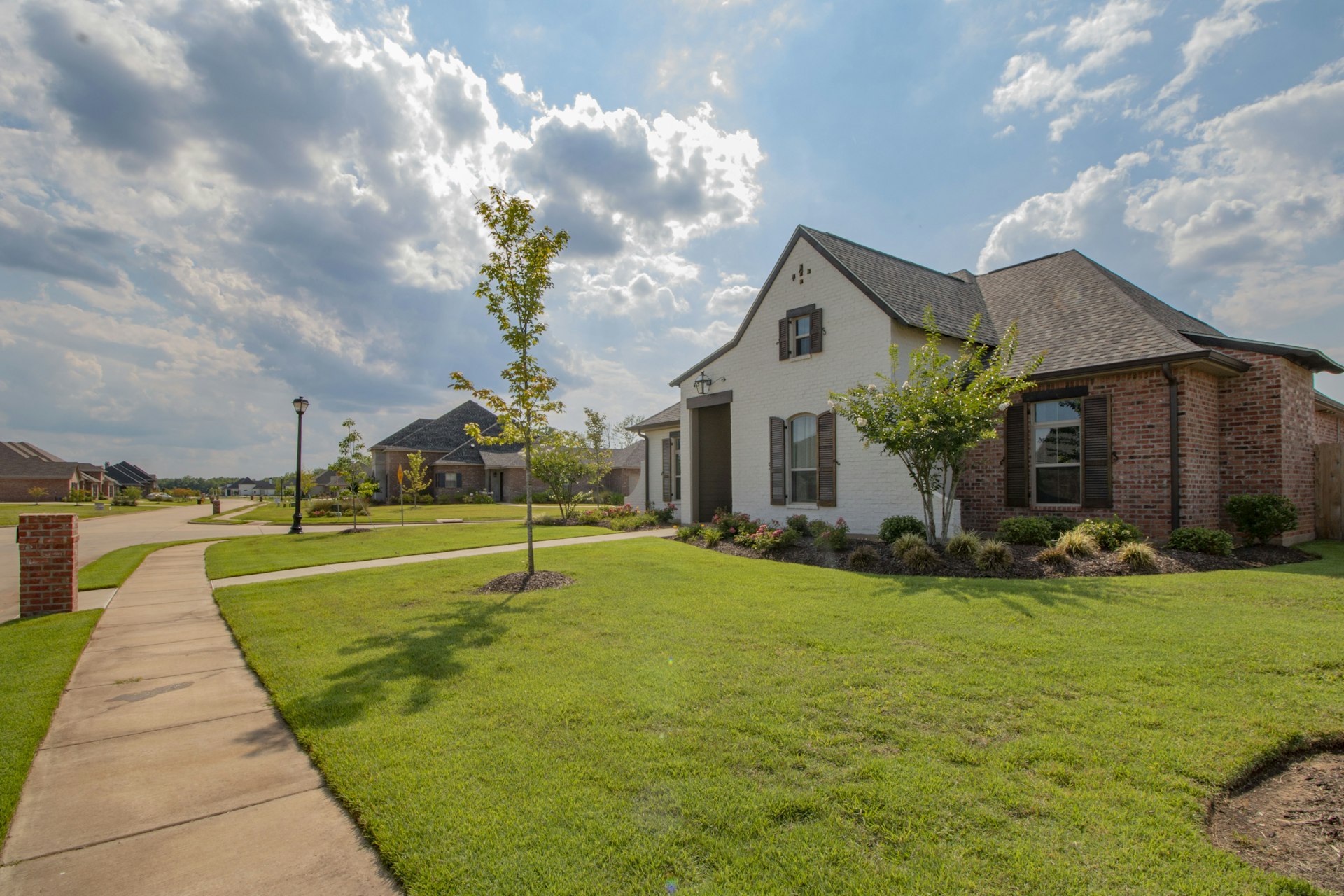 A front yard with fresh lawn, mulch beds and young trees